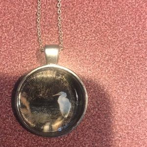 Silver toned round stork or crane pendant necklace